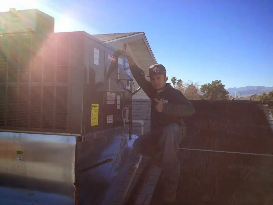 HVAC technician performing AC Tune-Up on a rooftop unit in Homeland Park